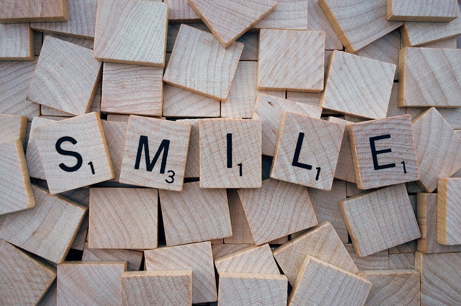 Scrabble-Spielsteine legen das Wort "SMILE"